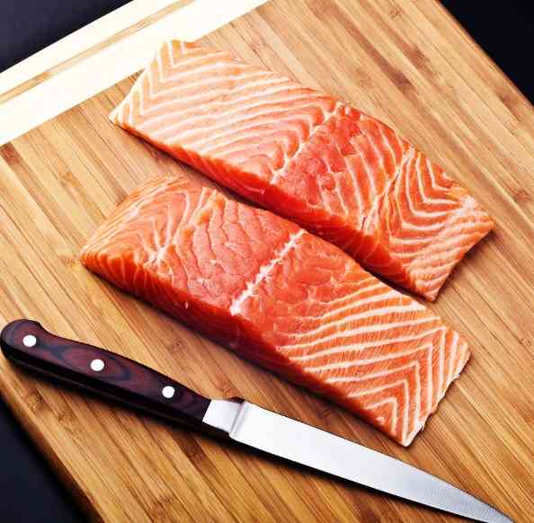 филе красной рыбы на разделочной доске 